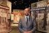 A museum curator stands in front of a colorful exhibit devoted to Washington DC history